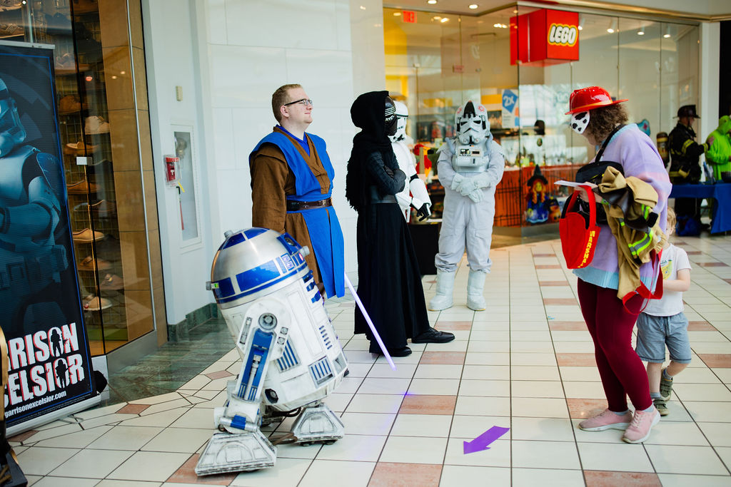 friends wearing Star Wars costumes at the event with an R2D2 robot