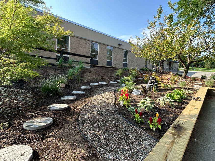 a photo of a garden with a stone path and colorful plants